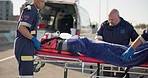 Road accident, paramedic and a person on a stretcher for medical attention, healthcare or an injury. First aid, help and an ambulance with an emergency patient in the street for danger or trauma