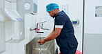 Surgeon cleaning hands, hygiene and doctor man, safety and water for washing away bacteria with healthcare. Health, wellness and African medical professional prepare for surgery with disinfection