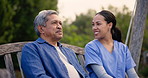 Senior man, park and talking with nurse happy from wellness outdoor and communication. Backyard, caregiver and portrait of a elderly male person in retirement with discussion and nursing professional