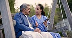 Nurse, phone and talking to senior man outdoor with social media, news or communication in backyard. Online, discussion and person with elderly care in retirement, garden or caregiver show a video