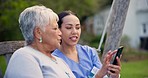 Nurse, phone and talking to senior woman outdoor with social media, news or communication in backyard. Online, discussion and person with elderly care in retirement, garden or caregiver show a video