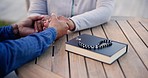 Couple, holding hands and praying together with bible, rosary and faith on table, outdoor and connection. People, support and book for religion, study and empathy with gratitude for holy spirit