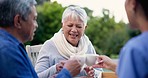 Cheers, nurse and a couple with coffee in a backyard for conversation, care and relax in the morning. Happy, toast and a female caregiver speaking to a senior man and woman during breakfast in nature