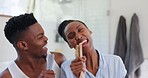 Happy couple, singing and dancing with brush in home for grooming, together or bond in bathroom. Black man, woman and married with karaoke in morning for fun, silly and smile for love in relationship