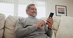 Senior, happy man and typing in home with phone, scroll social media or reading mobile news article. Elderly pensioner search internet, download digital app or chat of smartphone notification on sofa