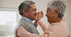 Elderly, couple and hug with dance in living room of home for bonding, romance and happiness or love. Senior, man and woman holding hands together or dancing in lounge of house for celebration or joy