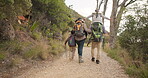 Family, hiking and holding hands outdoor, piggyback and care in countryside. Mother, father and kids trekking in forest, walk in nature or travel together on vacation, freedom or bonding on adventure