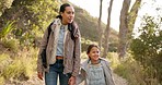 Mom, girl and outdoor on walk, holding hands or talk in forest with bonding for love, care and sunshine. Hiking, mother and daughter with freedom, chat and explore together in park, woods or nature