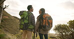 Couple, hiking and pointing on mountain for fitness, exercise and trekking or adventure in travel. Man and woman, holding hands and conversation on outdoor journey in nature, health and wellness