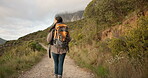 Woman, back and walk for hiking, outdoor or thinking with location, nature or freedom on vacation. Girl, hill and bush for trekking, backpack or exercise with direction, travel or mountain adventure