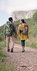 Backpack, couple holding hands and hiking in nature, travel and vacation together outdoor. Back, man and woman trekking in countryside on journey, adventure and walking for freedom, love and support