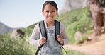 Smile, face and kid on a hike with backpack in nature on a mountain for outdoor travel holiday. Happy, excited and portrait of girl child on an adventure, vacation or weekend trip in countryside.