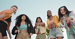 Friends, dance and below of group of women outdoors with trendy clothes, cool outfit and style on blue sky. Fashion, diversity and portrait of people in streetwear on holiday, vacation and weekend