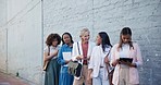 Waiting, recruitment and business women in queue for hiring, career opportunity or interview. Group, hr line and happy professional people job hunting, onboarding and talking by wall in city outdoor