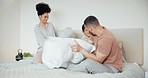 Happy, bed and family with pillow fight at their home having fun and bonding together on a weekend. Smile, playful and young boy child playing with his parents in bedroom of modern house in Canada.