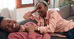 Funny, home and black couple on a couch, relax and weekend break with humor, love and marriage. African man, apartment and woman on a couch, relationship and laughing with joke and bonding together