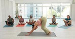 Yoga class, woman and instructor for meditation, calm and zen mindfulness in chakra, aura and holistic. Diversity group, fitness and downward dog pose for mental health, self care and inner balance