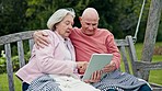 Nature, tablet and senior couple on a bench networking on social media, mobile app or internet. Digital technology, love and elderly man and woman in retirement scroll on website on swing in garden.
