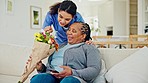 Home, flowers and elderly woman with caregiver for bonding, kindness and care in retirement. Nursing, health and nurse with bouquet for senior patient in living room for support, love and surprise