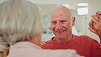 Senior couple, dancing and kitchen in home with smile for love, romance or bonding with wellness in retirement. Elderly woman, old man and happy together with steps, moving and holding hands in house