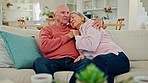 Hug, kiss and senior couple on a sofa relax, bond and sharing moment, comfort or peace at home. Love, retirement and old people in living room with trust, care or support while holding hands in house