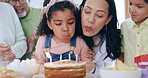 Happy family, little girl and blowing candles on birthday cake for celebration or special day together at home. Mother, grandparents and children smile applause for love, care or make a wish at house