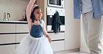 Parent, dancing and little girl twirling in kitchen of princess with cute dress at home. Happy child, dancer or ballerina kid in twirl or spin around for bonding, celebration or fun together at house