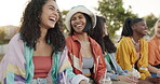 Friends, group and drinking a beverage with laughing, story or gossip in summer for bonding or happiness. People, girls and sitting on a park with conversation, diversity and joke for quality time
