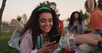 Happy woman, phone and relax with friends at park for social media, communication or outdoor picnic. Female person smile lying on grass or blanket with mobile smartphone for online chatting in nature