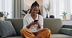 Black woman on sofa, laughing or typing on phone for meme, social media or blog post with smile in home. Happy girl on sofa with smartphone checking email, funny website or online chat in living room