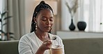 Black woman on couch, eating ice cream and relax in living room with smile, summer pleasure and enjoy. Happiness, fun or thinking, girl on sofa with taste of frozen chocolate gelato dessert in home.