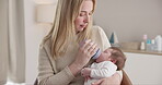 Milk, bottle and a mother feeding her baby in a bedroom of their home together for love, growth or care. Family, nutrition or formula and a newborn infant drinking with a woman parent in apartment