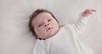 Baby, calm face and above in the morning on nursery bed and blanket awake from nap and rest. Relax and newborn with happy smile on bedding from waking up from sleeping in a family home and bedroom