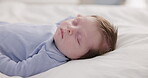 Relax, growth and sleep with a baby on a bed closeup in a home, dreaming during a nap for child development. Kids, calm and rest with an adorable newborn infant asleep in a bedroom for comfort