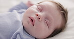 Face, relax and sleep with a baby on a bed closeup in a home, dreaming during a nap for child development. Growth, calm and rest with an adorable newborn infant asleep in a bedroom for comfort