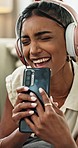 Music, phone and happy woman singing with headphones at home for stress relief, break or fun while streaming. Smartphone, app and female person with radio, karaoke or audio podcast in a living room