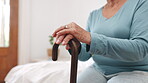 Walking stick, hands and senior woman with disability, healthcare support and osteoporosis in retirement. Closeup, elderly patient and pensioner with cane for parkinson, arthritis and help in bedroom