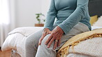 Knee pain, hands and senior woman in home with arthritis, joint ache and osteoporosis in bedroom. Closeup, elderly healthcare and massage legs for fibromyalgia, orthopedic injury or medical emergency