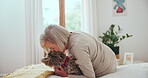 Senior woman, dog or kiss in bedroom for love, care or pet friend for wellness in retirement. Elderly person, domestic animal or bonding in happy together, puppy for mental health or smile in house