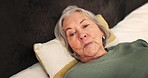 Senior woman, face and bed in retirement, thinking and sad in bedroom, stress and depression. Elderly person, portrait and nursing home for rest, mental health and alzheimers at home, insomnia or old