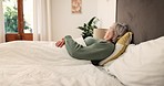 Senior, woman and tired for thinking in bedroom for sleepless, stress or insomnia for wellness. Elderly person, alone and lying for rest with fatigue, sadness or exhaustion with mental health in home