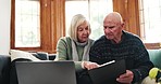 Home, laptop and documents with senior couple, finance and conversation with pension fund, retirement and investment. Apartment, old man and elderly woman with a pc, paperwork and discussion for debt