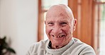 Face, home and old man with a smile, relax and retirement with humor, wellness and laughing in a lounge. Portrait, elderly person and pensioner with happiness, joy and apartment with senior guy