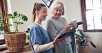 Nurse, tablet and senior woman talking, communication and consultation in home. Caregiver, technology and happy elderly person with coffee, phone app and good news or surprise on healthcare report