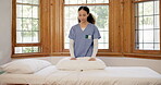 Assisted living, nurse and a woman making the bed in a retirement home for healthcare or hospitality. Medical, bedroom and a happy young caregiver in an apartment for service work or assistance