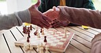 Closeup, people and checkmate for win on board with congratulations by handshake for game. Person, planning and strategy in chess for competition, challenge or tournament by table, park or outside