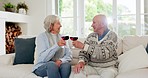 Love, cheers and senior couple with wine in the living room for bonding together at modern house. Happy, smile and elderly man and woman in retirement drinking alcohol on a sofa in the lounge at home