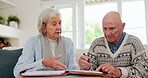 Senior couple, agreement and signing in retirement, contract and paperwork or documents. Elderly people, marriage and conversation or communication for future, planning and investing on couch at home