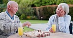 Juice, retirement and an old couple playing chess together outdoor in the garden of their senior home to relax. Love, thinking or strategy with an elderly man and woman in the yard for a board game