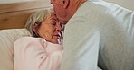 Elderly, couple and kiss forehead in bed for support, sick and conversation with retirement or healing. People, man and woman in bedroom with communication, empathy and love for trust, care and rest